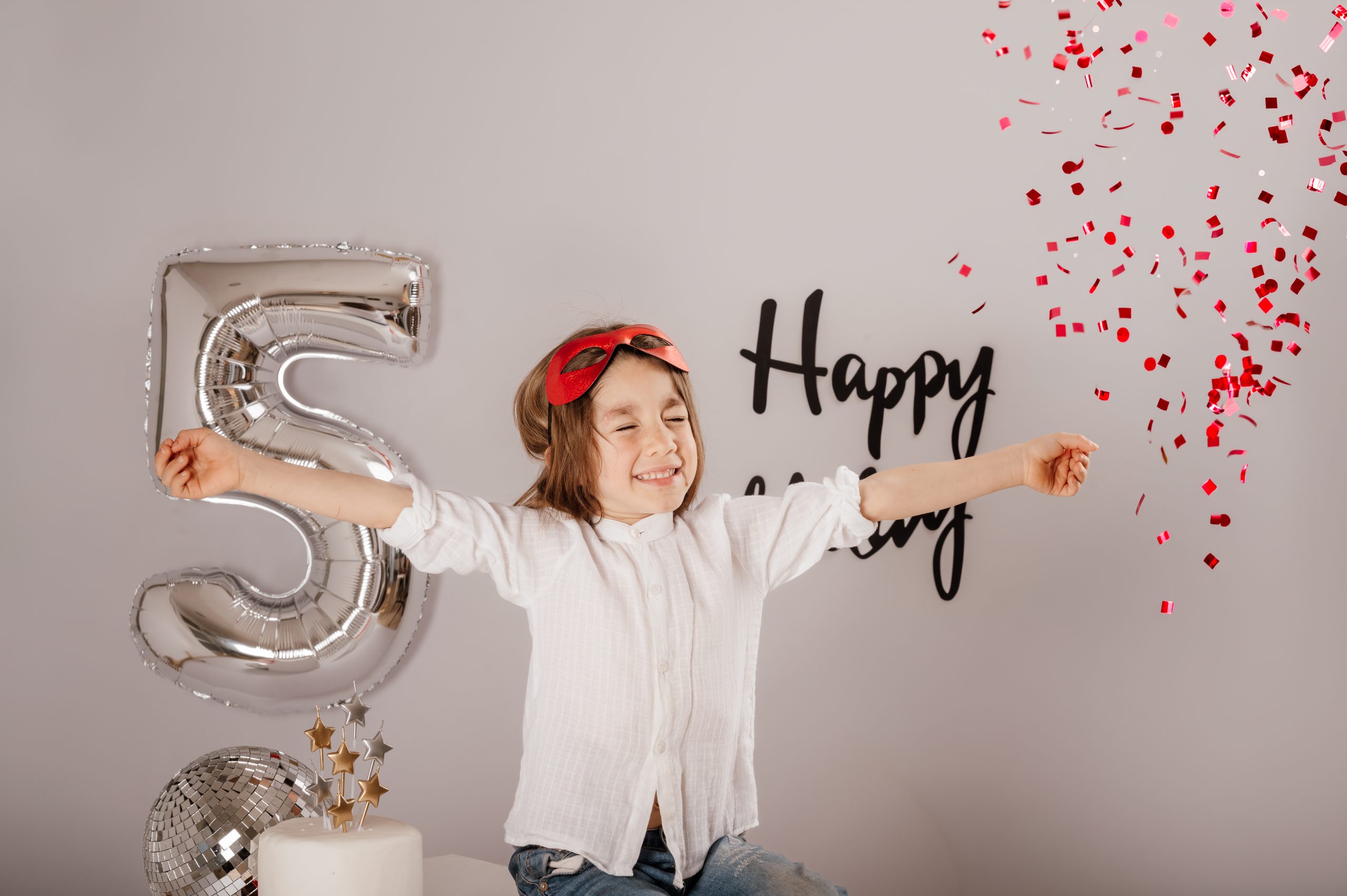 sesion de cumpleanos infantil en Corredor del Henares Thiago 5 anos con confeti rojo estilo superheroe en estudio